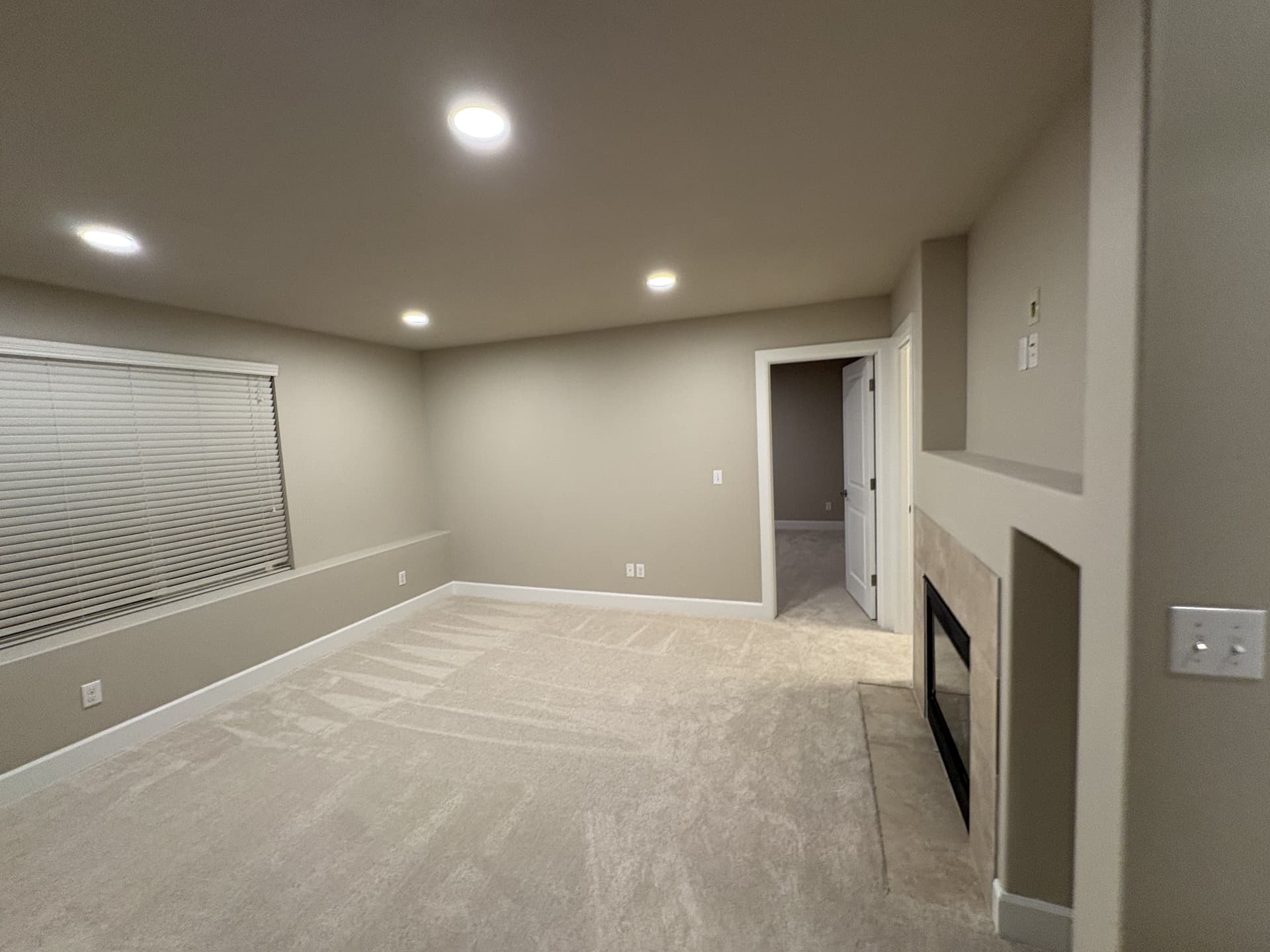 Finished living room with new carpet and a tiled fireplace