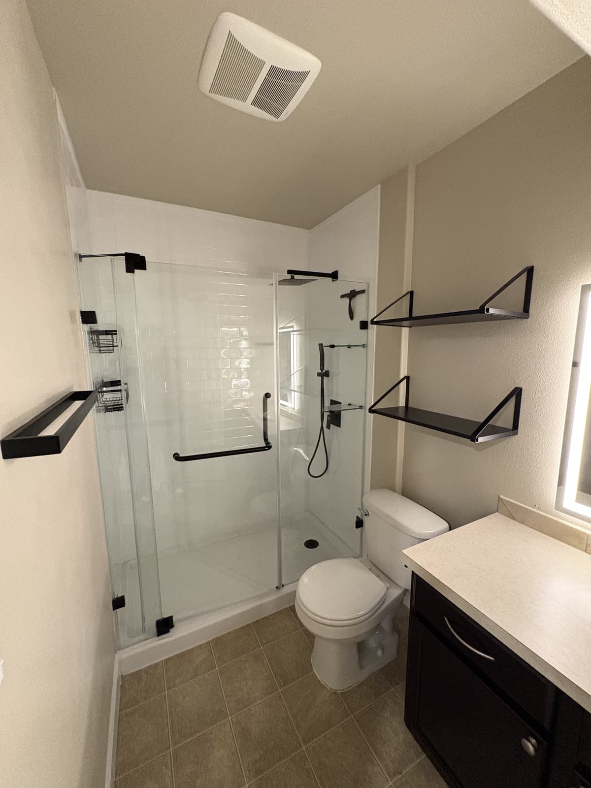 Bathroom with new shelving, towel bars and glass shower