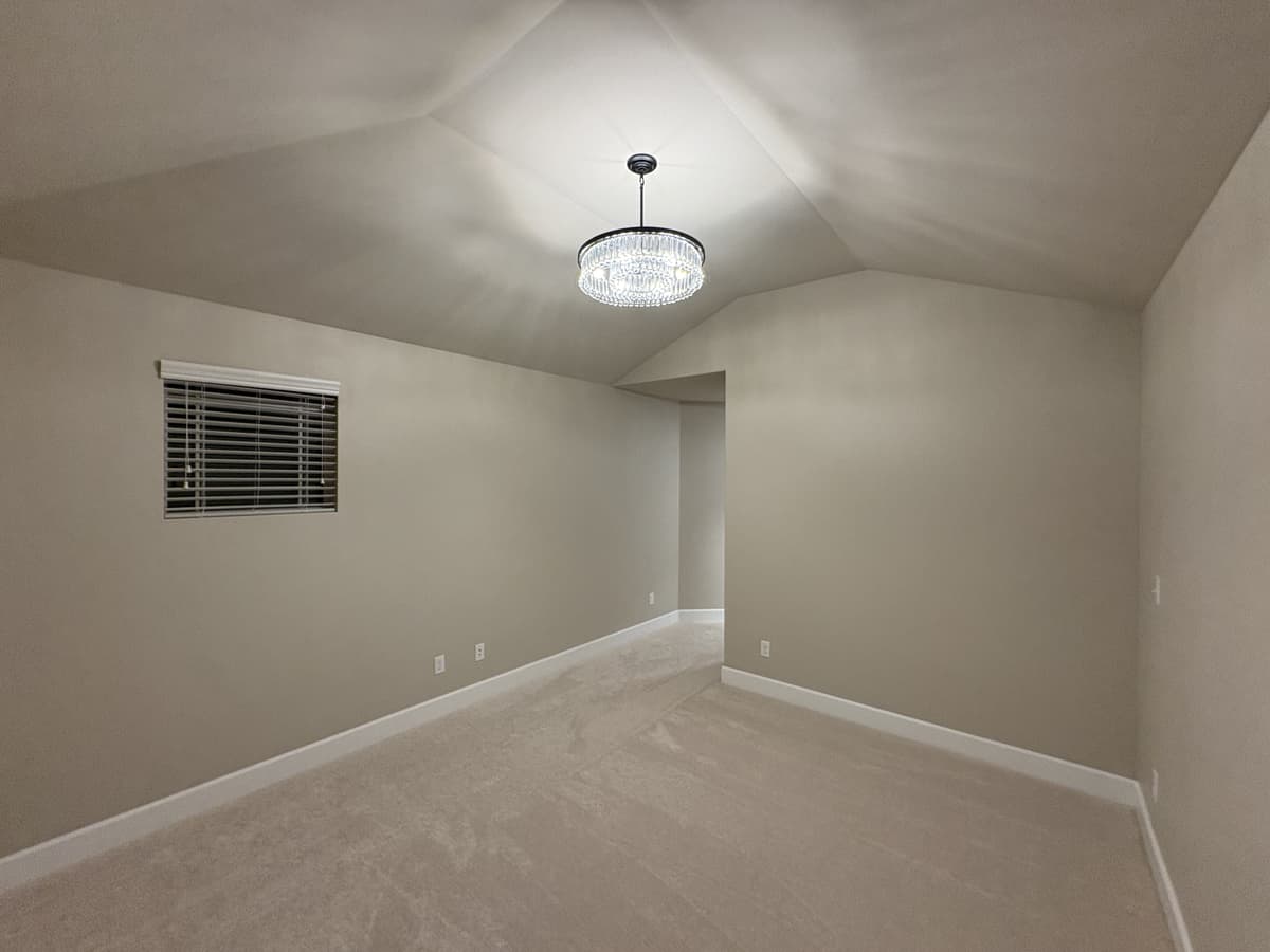 Vaulted-ceiling bedroom after carpet replacement, repaint and a new chandelier